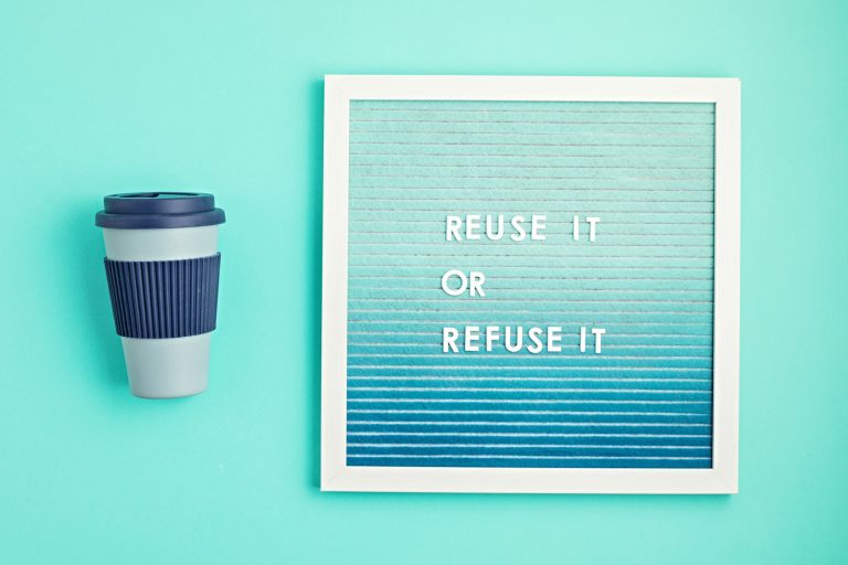 Reusable coffee cup and letterboard with text reuse it or refuse it. Zero waste sustainable