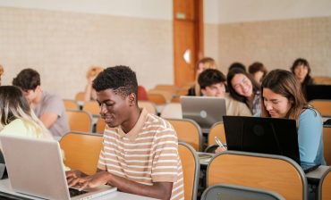 University students taking notes on the computer and paying attention in class